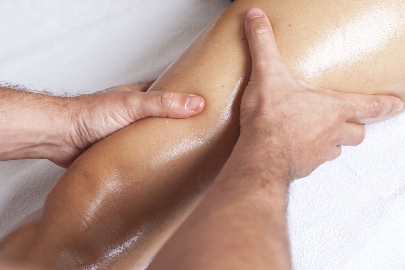 Sports massage therapist working on a calf muscle